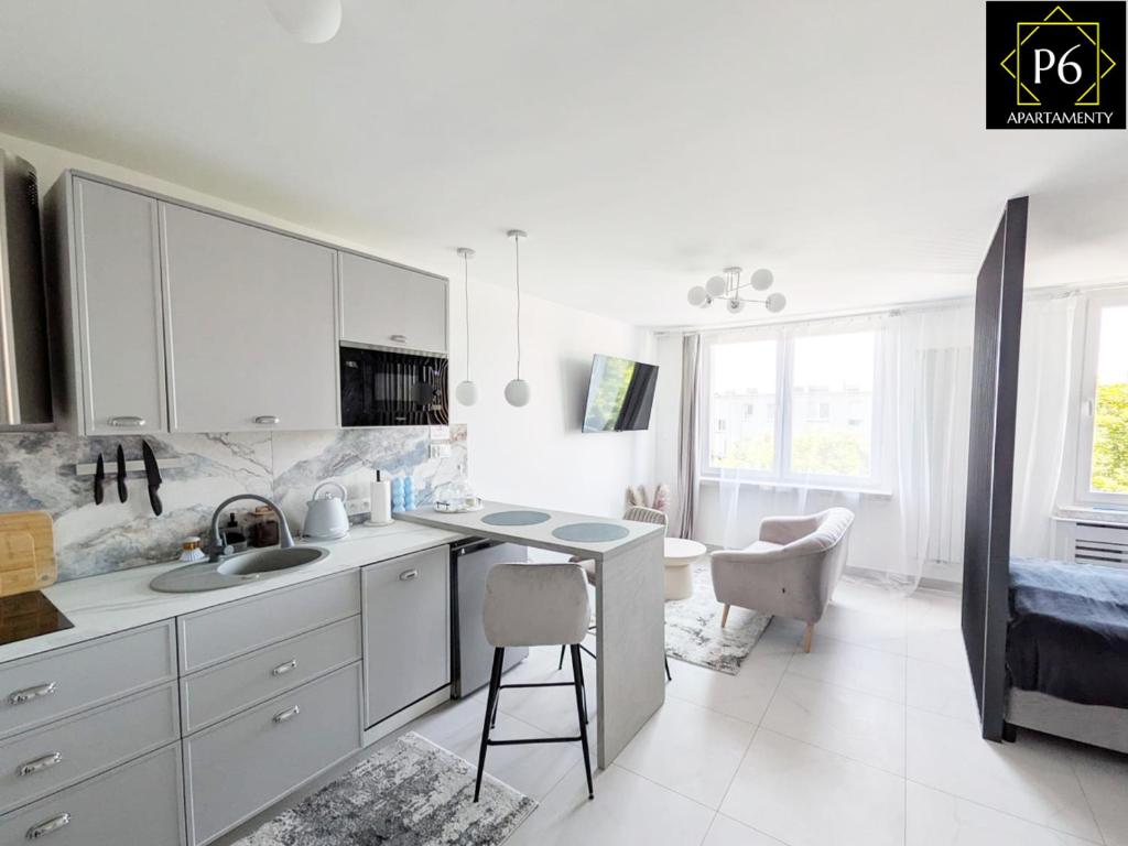 a kitchen with white cabinets and a sink and a stool at P6 Lipowa in Pisz