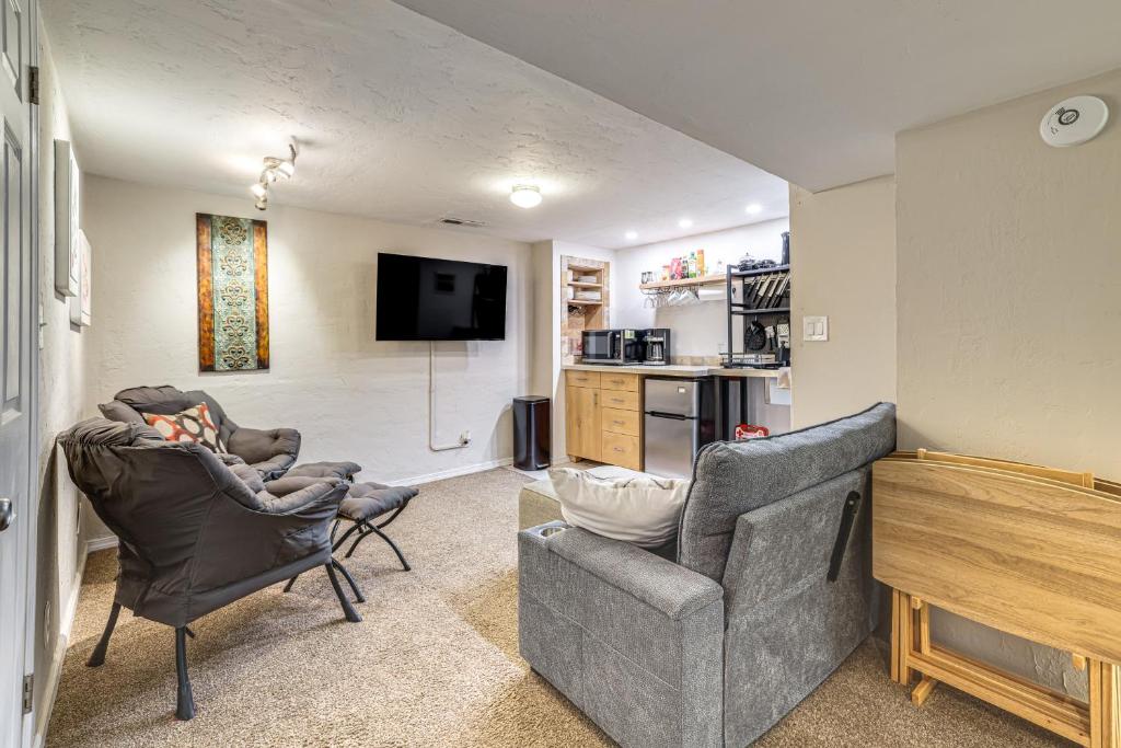 a living room with two chairs and a flat screen tv at Work, Play & Explore w/ Ease! Dtwn Meridian Apt in Meridian