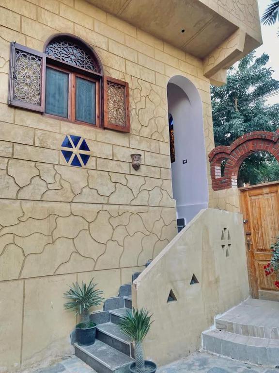 a house with a stone wall and stairs and a door at Rahma House Hostel in Tunis