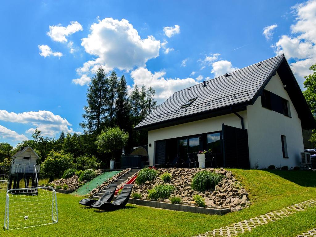 a house with a playground in front of it at Domek Veron in Wysowa-Zdrój