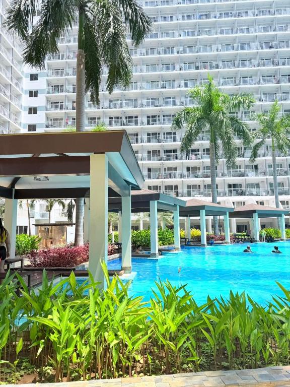 a hotel swimming pool with a large building in the background at Shell Residences MOA Elegant Place in Manila