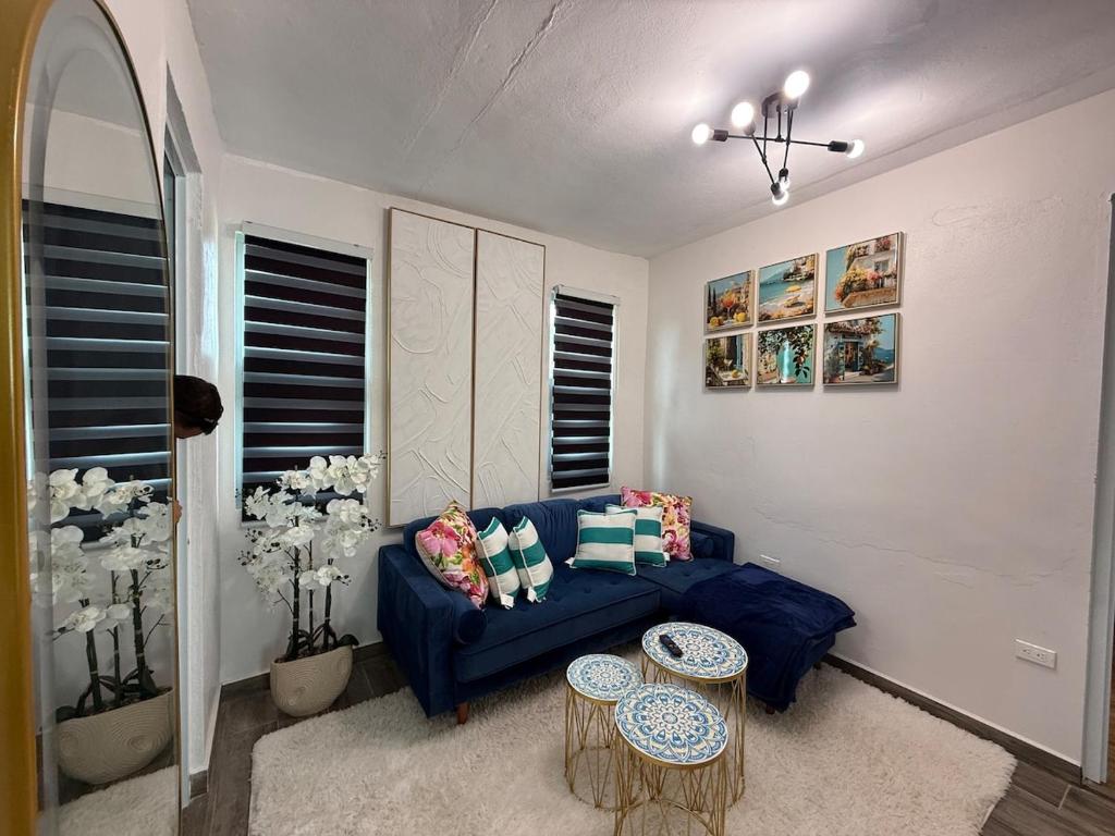 a living room with a blue couch and two tables at Monterosso By Cinque Terre in Isabela