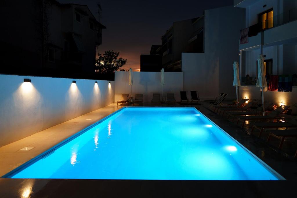 ein Schwimmbad bei Nacht mit blauer Beleuchtung in der Unterkunft Noema Hotel in Syvota