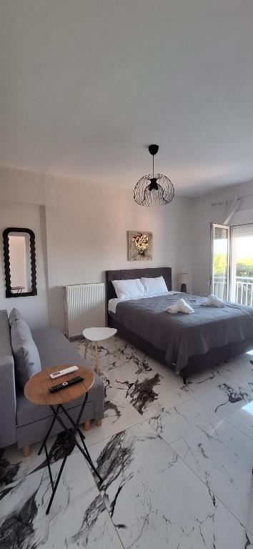 a bedroom with a large bed and a couch at Imeros Summer Home 3 in Ímeros