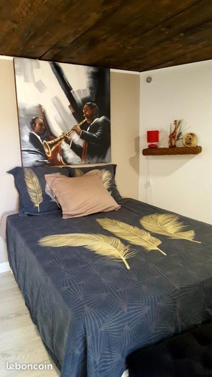 a bedroom with a bed with a poster on the wall at chambre hote independante in Le Mas-dʼAzil
