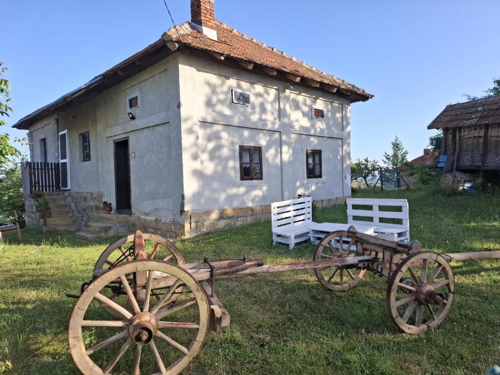 an old cart in front of a building at Dragačevska kuća na bregu- Heritage House in Viča