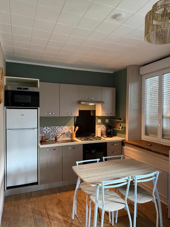 a kitchen with a table and chairs in it at Le pensionnat de Jeanne in Domrémy-la-Pucelle