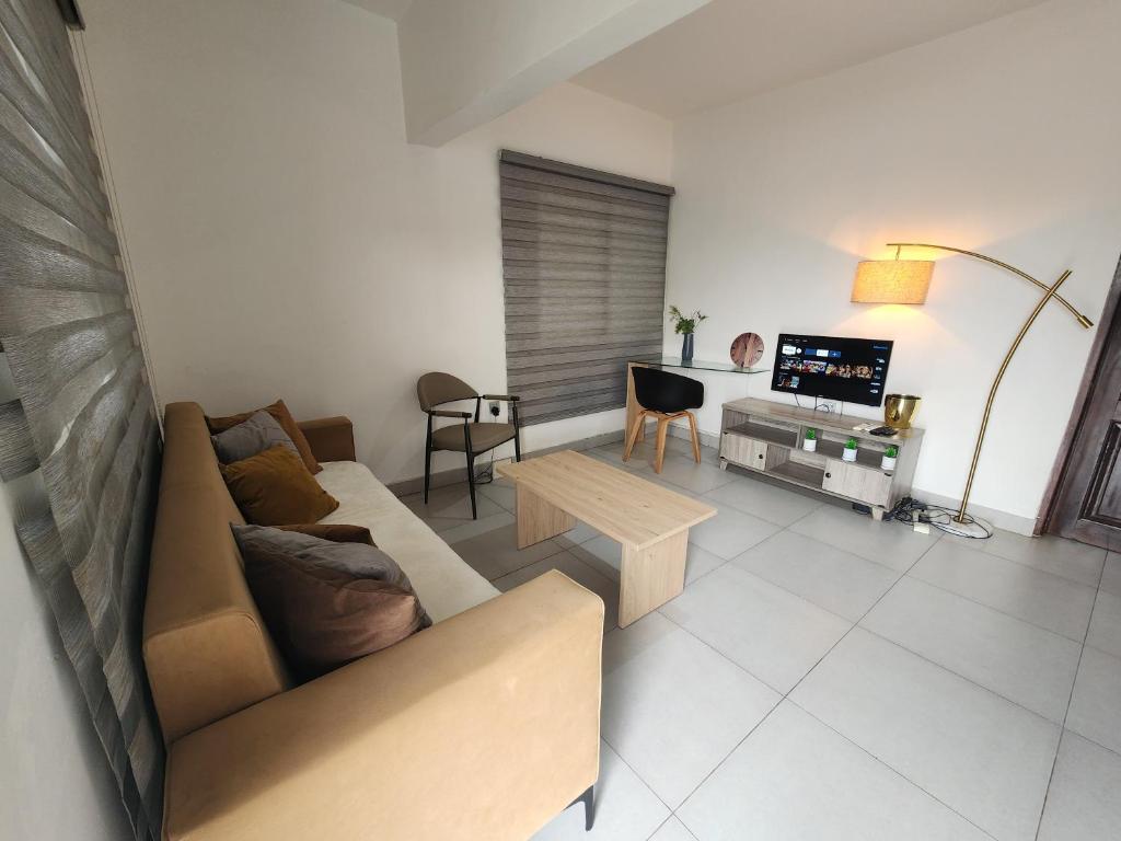 a living room with a couch and a table at SBJ Place East Legon in Accra