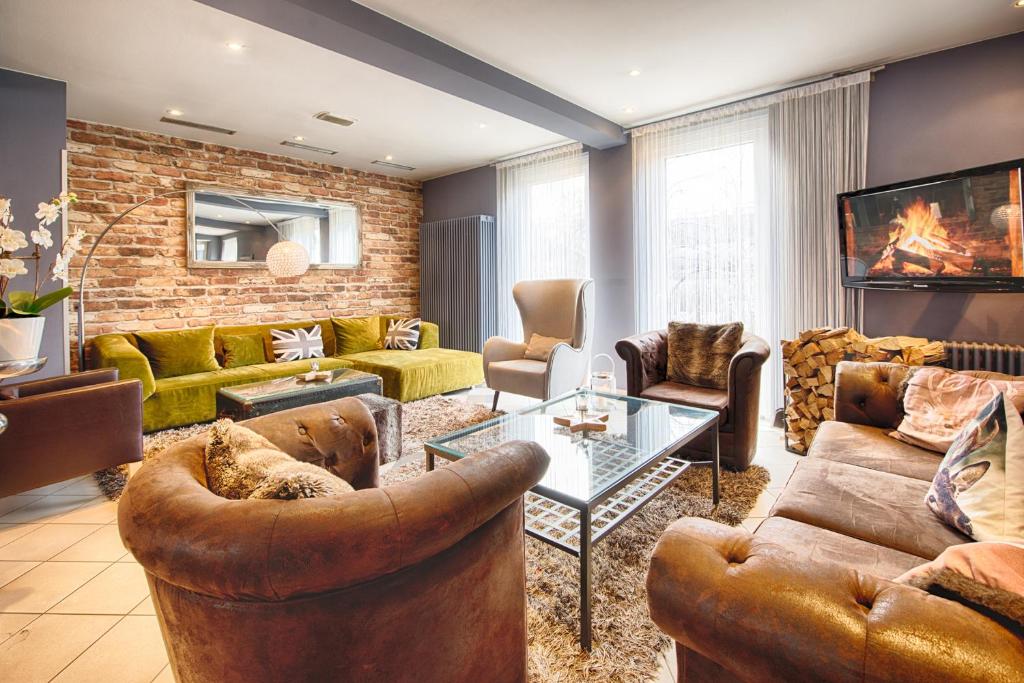 a living room with leather furniture and a brick wall at enjoy hotel Berlin City Messe in Berlin