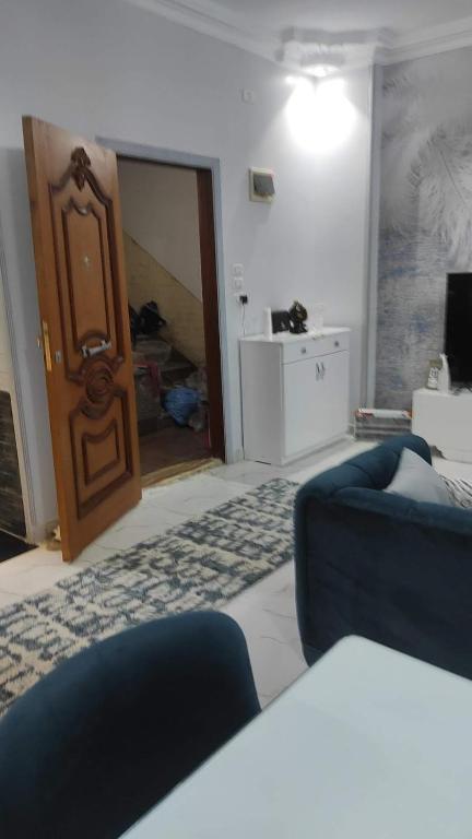 a living room with a blue couch and a wooden door at Heaven 2 in Mīt Abū Shaykhah