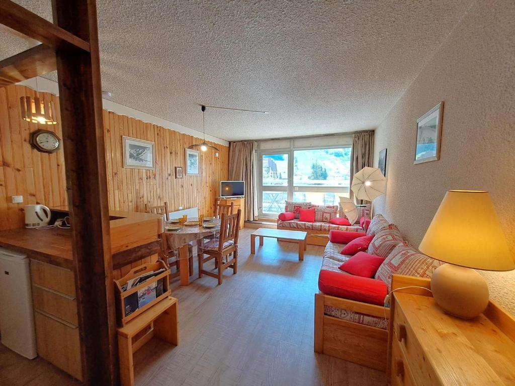 a living room with a red couch and a table at Studio 4 pers, centre station Les Deux Alpes, animaux admis - FR-1-516-75 in Les Deux Alpes