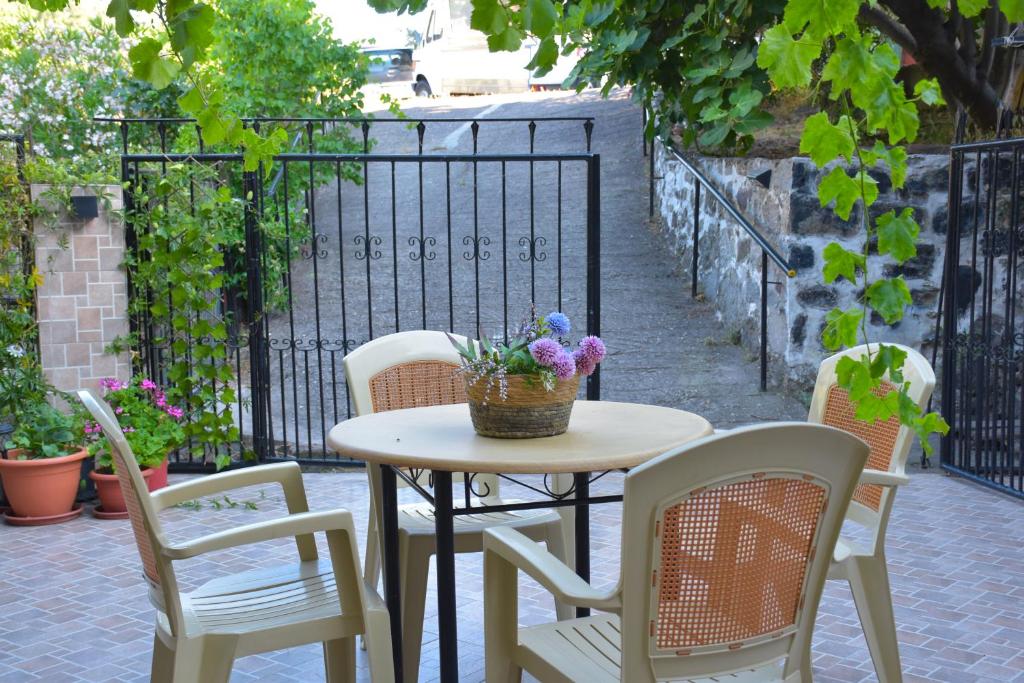 a table and chairs with flowers on a patio at Lazatka in Samothraki