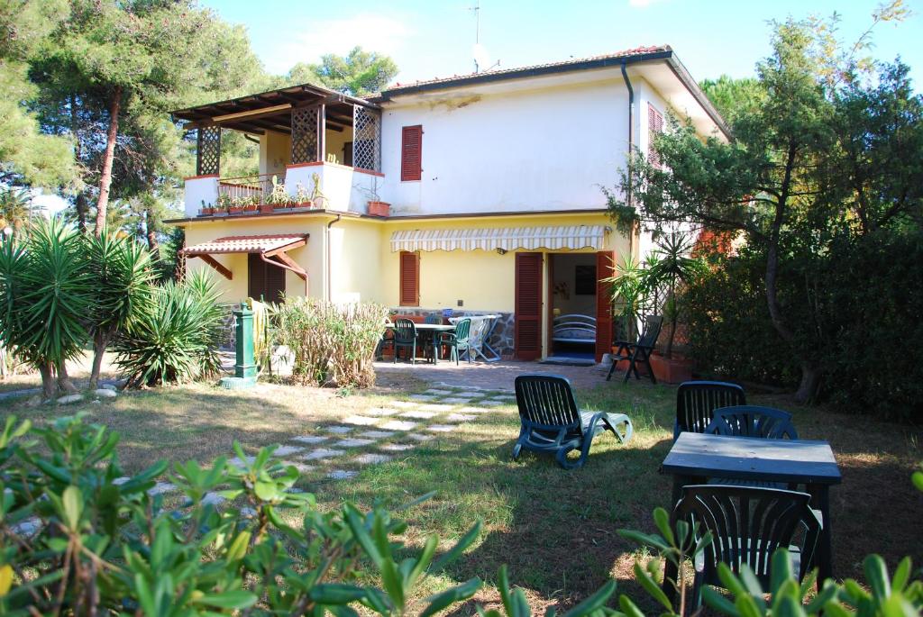 una casa con 2 sillas y una mesa en el patio en Appartamenti Acacia e Gardenia en Marina di Campo