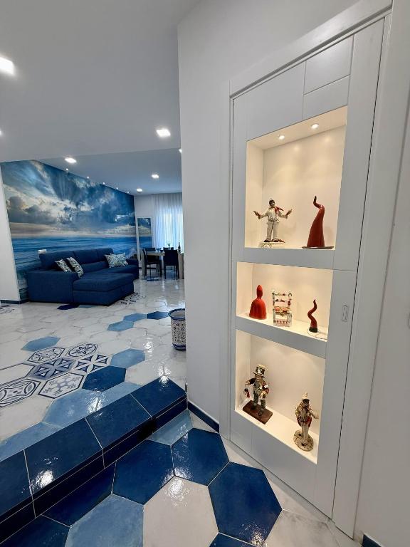 a room with a blue and white floor and shelves with figurines at Capri House - camera Luna Caprese in Minori