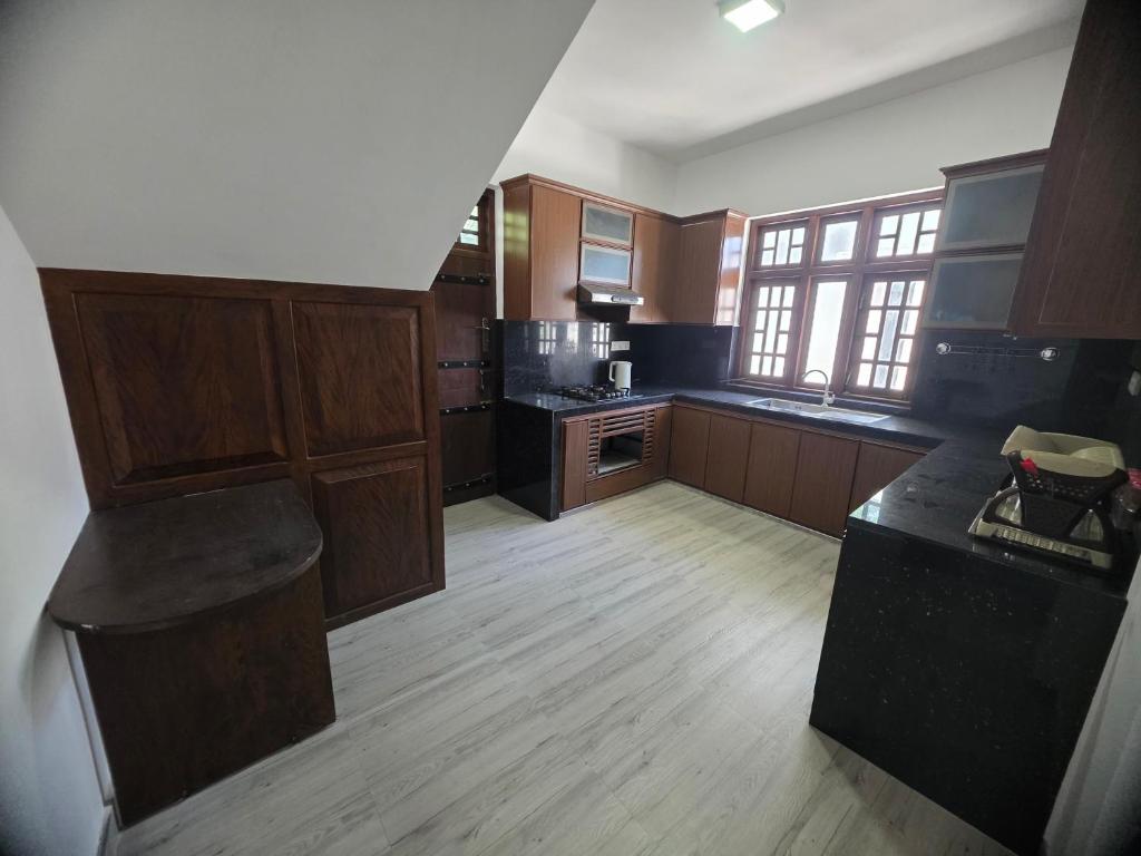 a large kitchen with wooden cabinets and a counter top at Villa at 37 in Badulla
