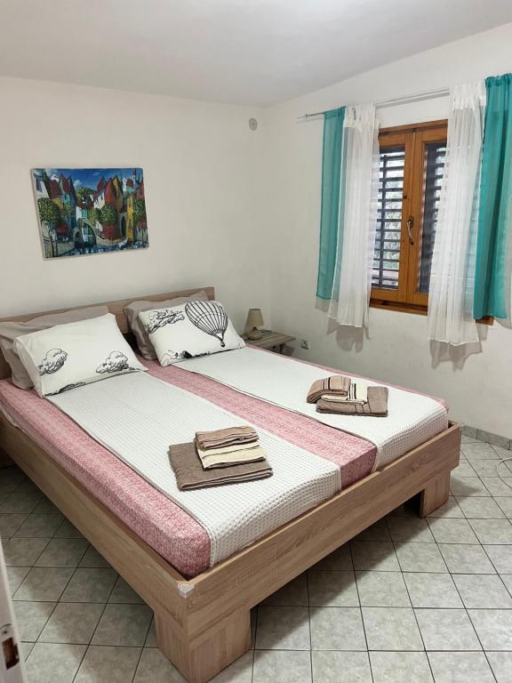 a bed in a bedroom with two towels on it at Vila Maša in Utjeha