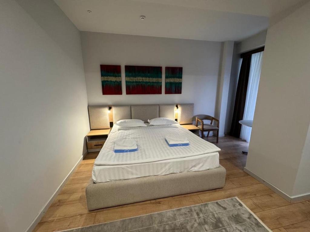 a bedroom with a large bed in a room at Raduga West Apart Hotel in Koshkolʼ