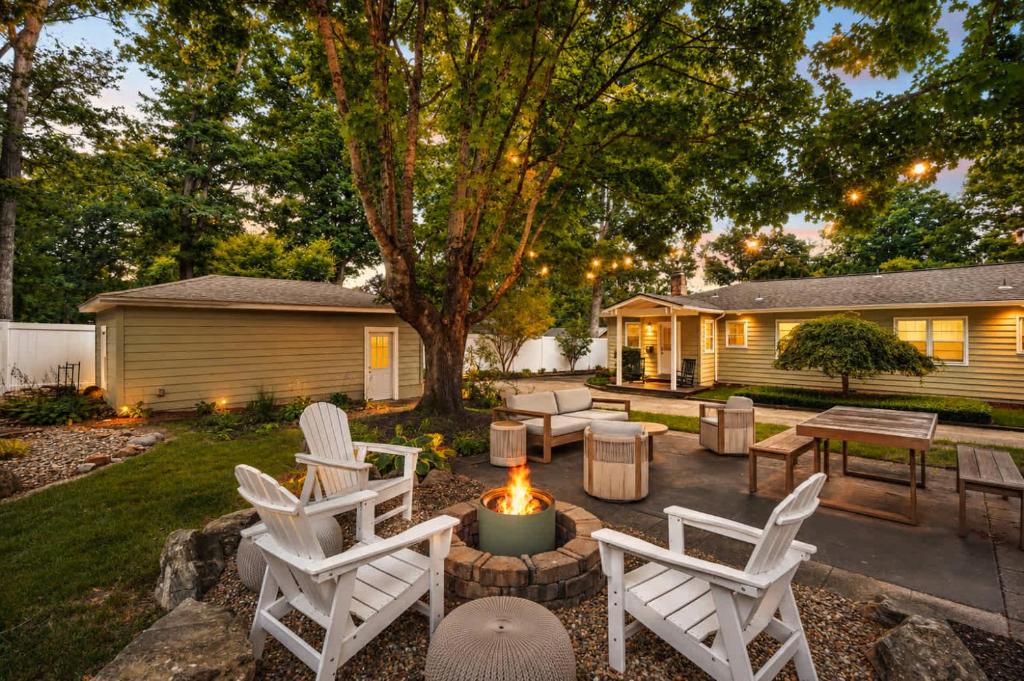 a backyard with white chairs and a fire pit at Black Mountain Bungalow Steps to Town Backyard in Black Mountain