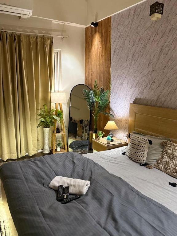 a bedroom with a large bed and a mirror at Nest And Rest Stay in Greater Noida