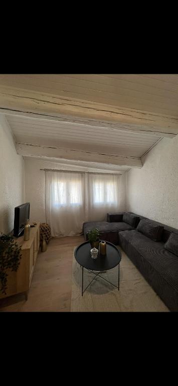 a living room with a couch and a table at Apparemment Cocooning Ceyreste in Ceyreste