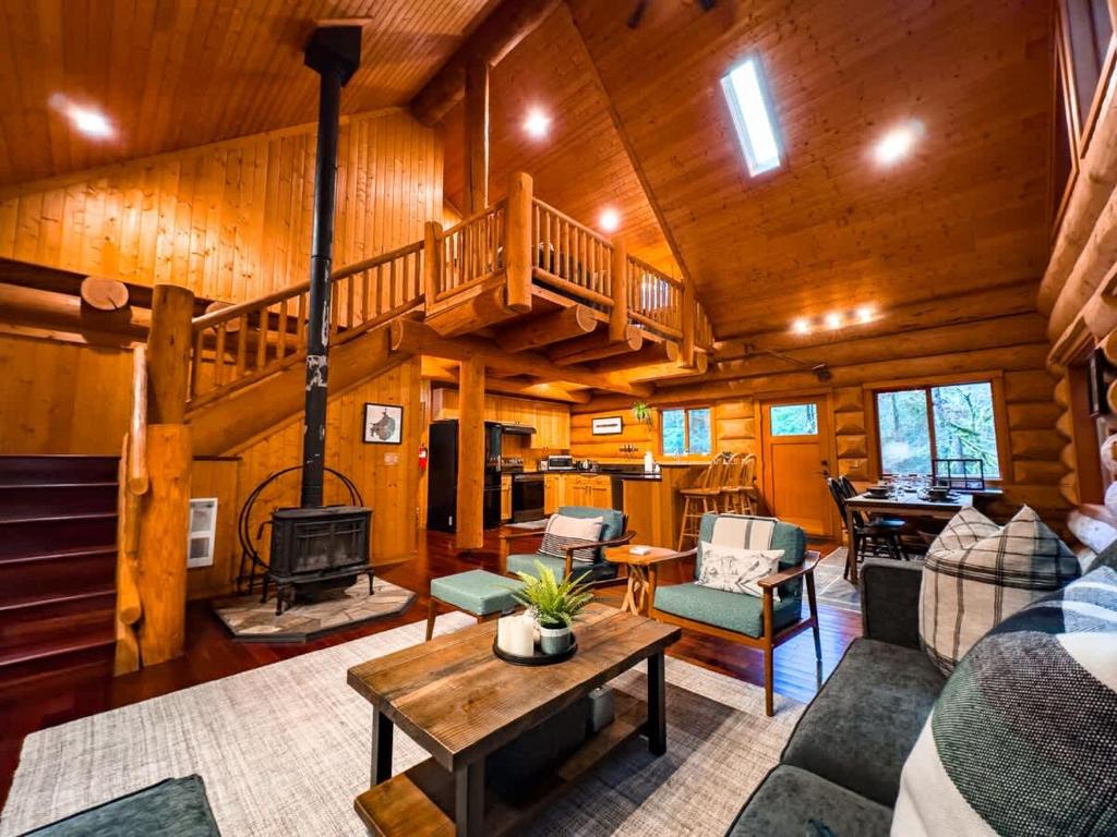 a living room with a staircase in a cabin at Wilderness Retreat in Glacier