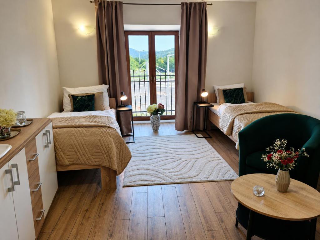 a hotel room with two beds and a balcony at Station rooms Trenčín in Trenčín