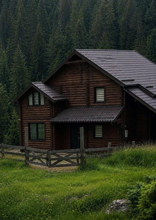 a log cabin with a fence in front of it at Forest House in Yablunytsya