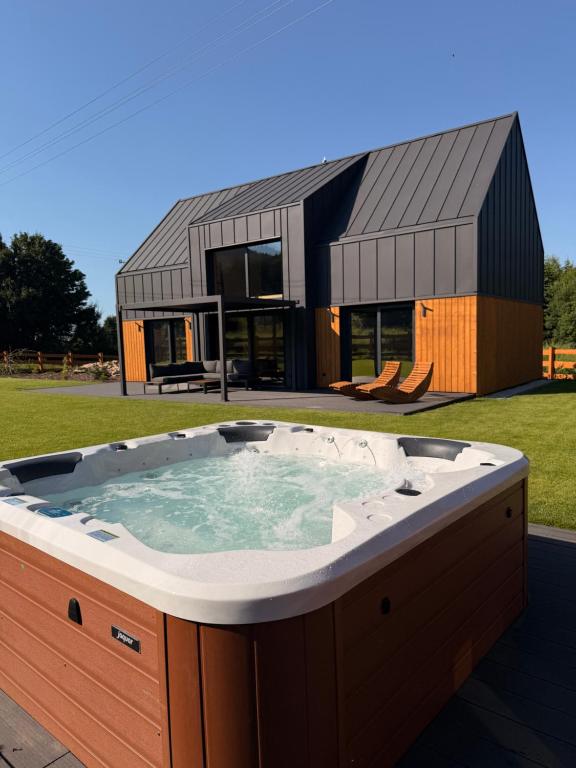 a large hot tub in front of a house at 4Sosny, jacuzzi, siłownia, sauna, widok na Śnieżkę in Miłków
