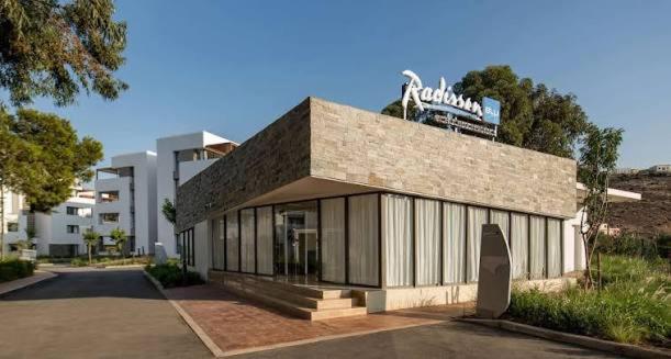 a building with a sign on the top of it at Radisson blu résidence alhcoeima in Al Hoceïma
