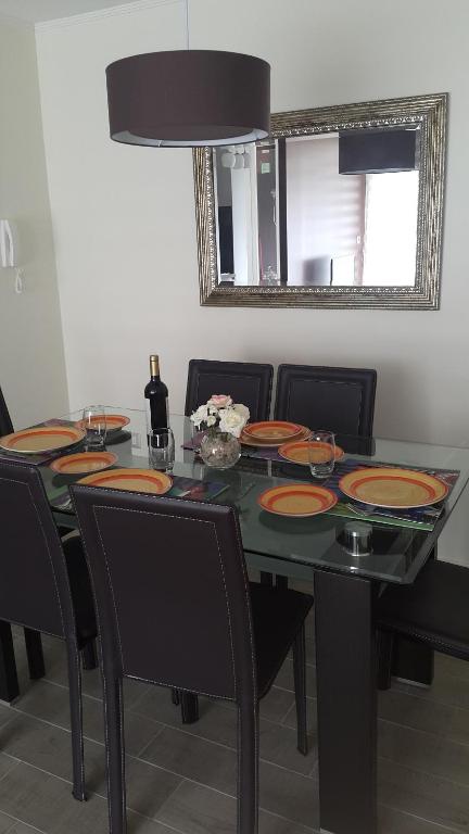 a dining room table with plates on top of it at Edificio Parque Almagro in Chillán