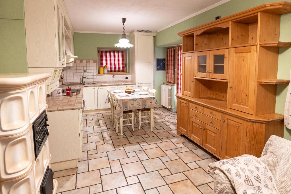 a kitchen with wooden cabinets and a table in it at Appartamento TreZero in Valfurva