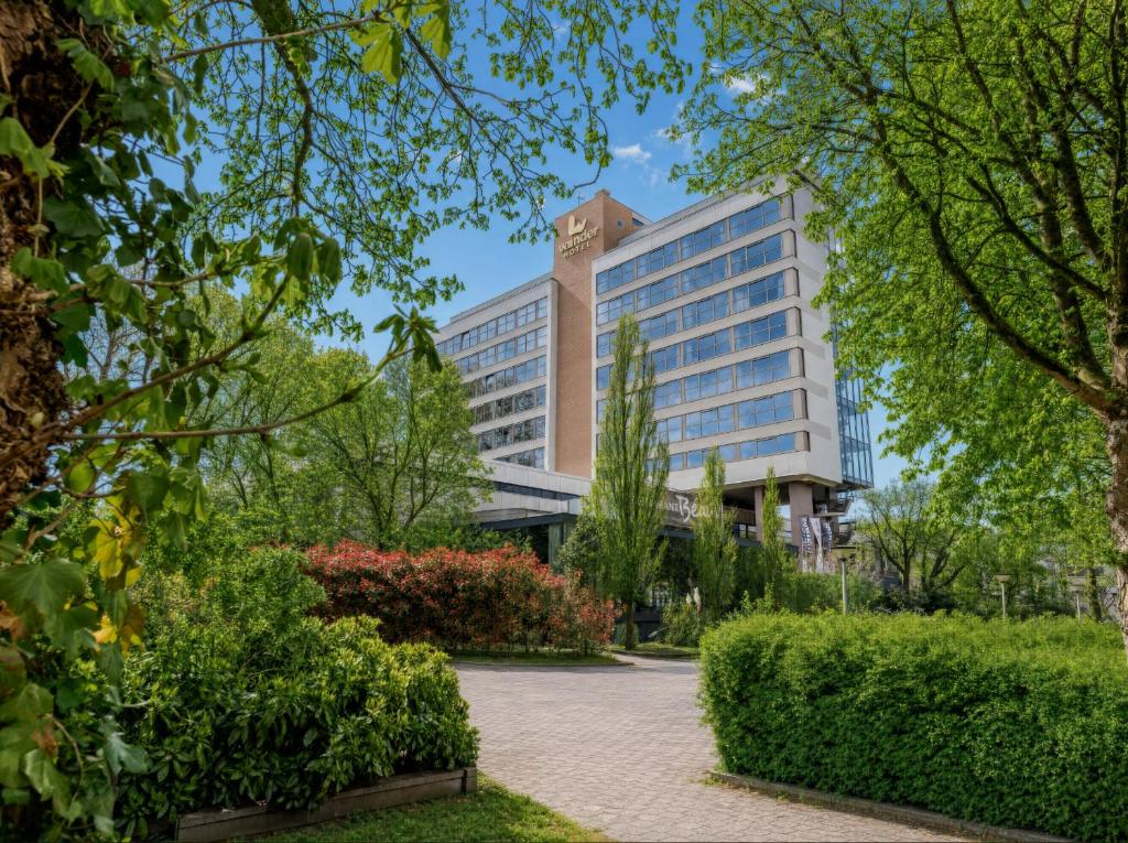 a building in a park with trees and bushes at Hotel Wander in Wageningen