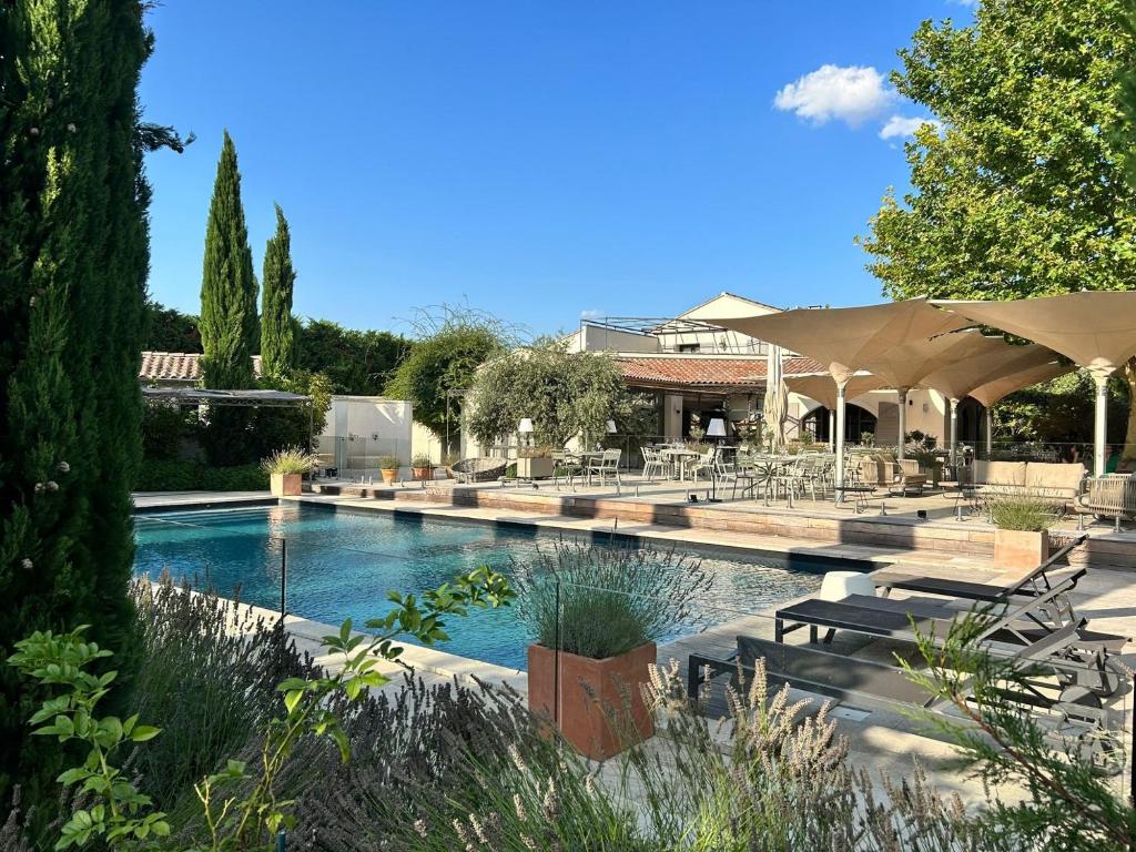 a swimming pool with chairs and umbrellas at La Villa Saint-Antoine in Violès