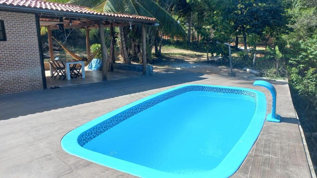 a large blue swimming pool next to a house at Encanto na Mata in Mata de Sao Joao