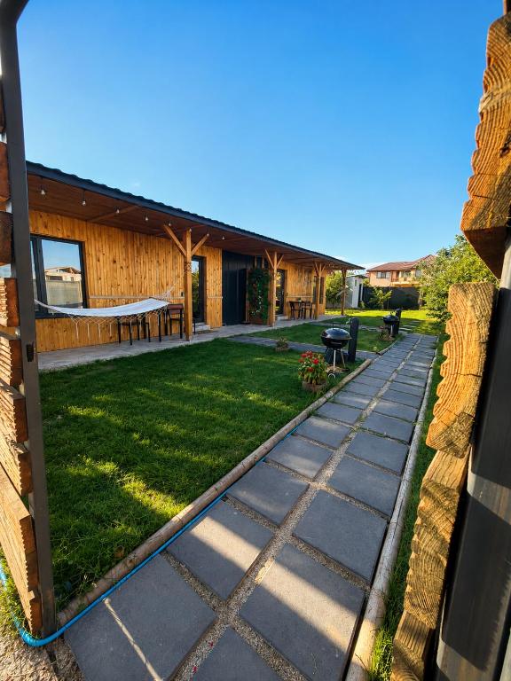 a garden with a stone walkway next to a house at MR Tiny House - Private Parking in Roşu