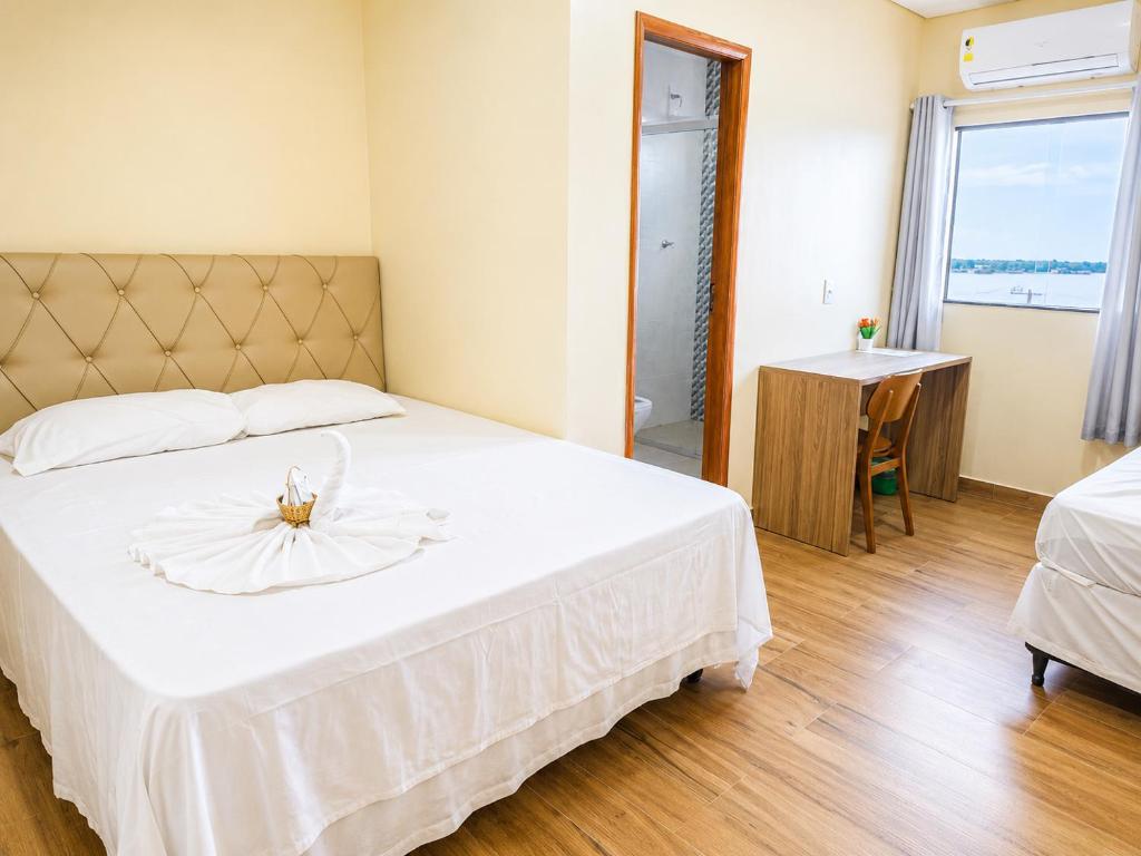 ein Schlafzimmer mit einem großen weißen Bett und einem Fenster in der Unterkunft Sumaúma Hotel in Tefé