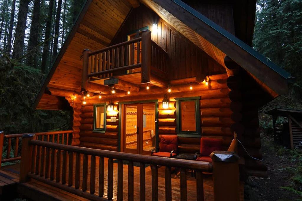 eine Hütte mit Lichtern auf der Veranda bei Nacht in der Unterkunft Forest Embrace in Glacier