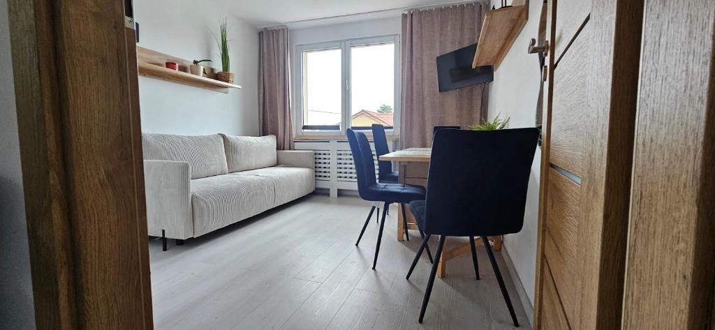 a living room with a table and chairs and a couch at Apartament Słowackiego Sopot in Sopot