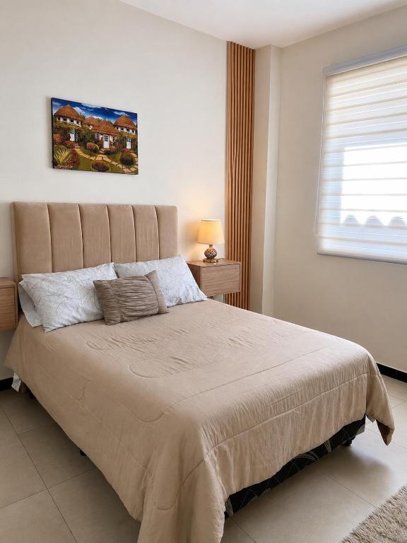 a bedroom with a large bed in a white room at Garzonier vacacional in Sucre