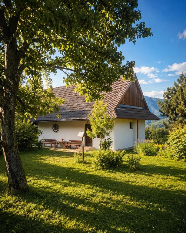 a white house with a picnic table and a tree at Chata Donovaly Bully 242/B in Donovaly