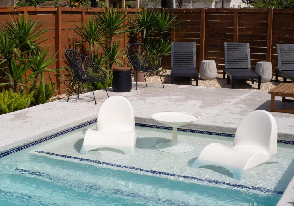a swimming pool with chairs and a table in the water at Astra B, Designer 3BR, Arcade, Heated Pool in Port Isabel
