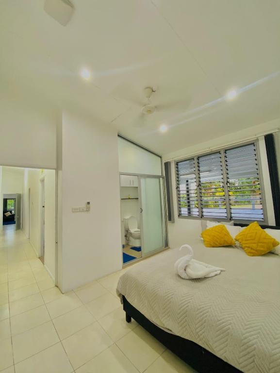 a bedroom with a large bed with yellow pillows at Muaicolo House in Suva