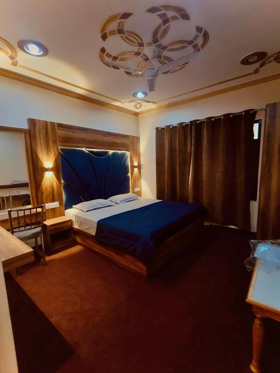 a bedroom with a blue bed and a chandelier at The Sapphire Retreat in Srinagar