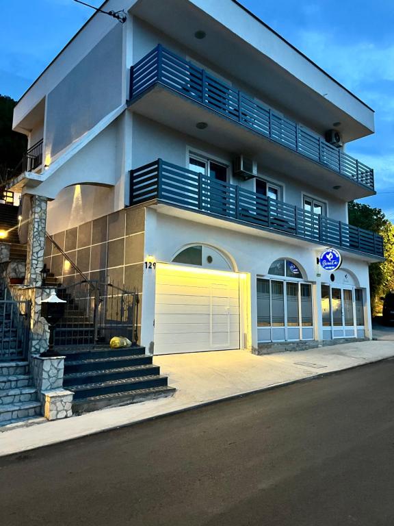 a white building with a yellow garage door at Bonita Apartments in Mostar