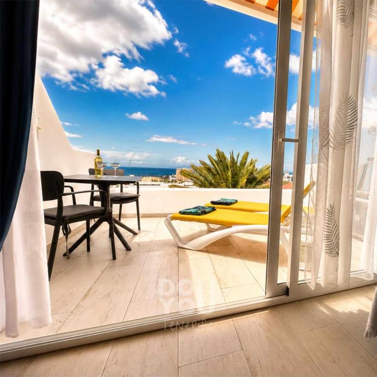 a balcony with a table and a view of the ocean at Holiday Apartments Oasis in Los Cristianos