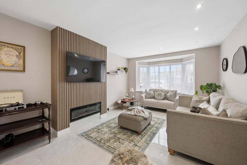 a living room with a couch and a tv at Spacious Modern home in the heart of Whitefield - Private Driveway Parking in Whitefield