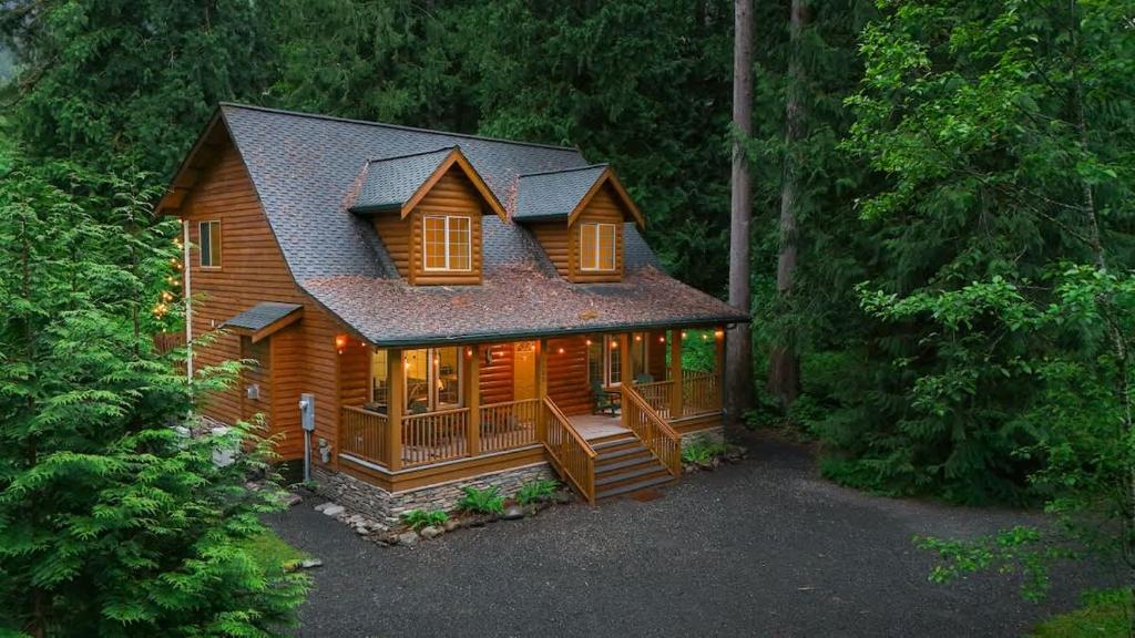 a log cabin in the woods with lights on at Hearthstone in Deming