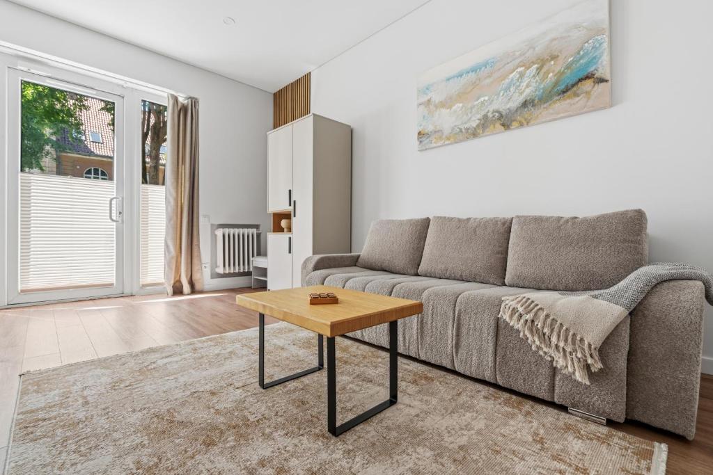 a living room with a couch and a table at Spacious Studio Near Station Klaipėda in Klaipėda
