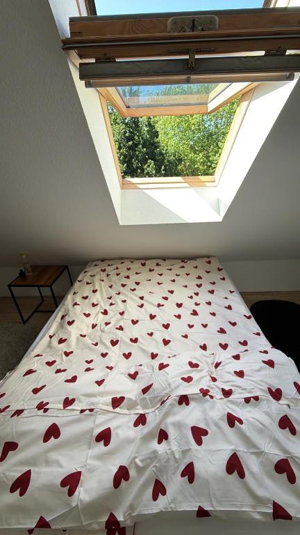 a bedroom with a bed with a window with red hearts at Gemütliches Zimmer İdeal Für Kurze Aufenthalte in Elmshorn