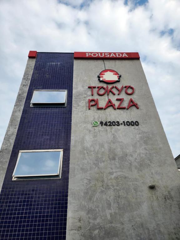 a tall building with a tokyo plaza sign on it at Pousada Tokyo Plaza in Mogi das Cruzes